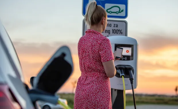 Woman paying for electric car charging 