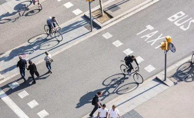 People using the pedestrian crosswalk on a busy street