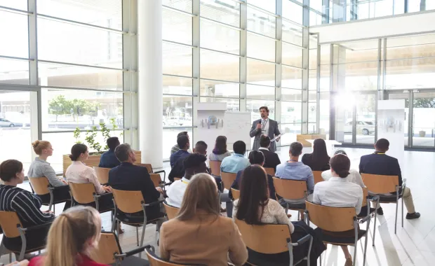 People sat at a conference listening to speaker
