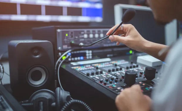 Professional in front of broadcast control panel