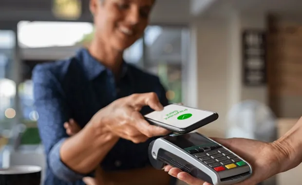 Person paying for purchase via contactless mobile phone payment