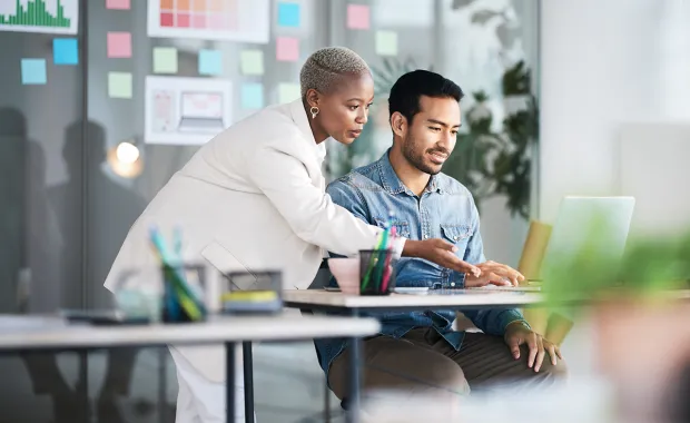 A man and a woman working together on a laptop