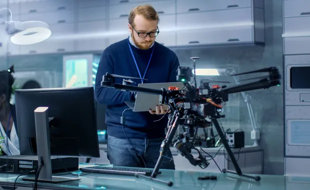 IT professional working on drone with mounted machine vision cameras