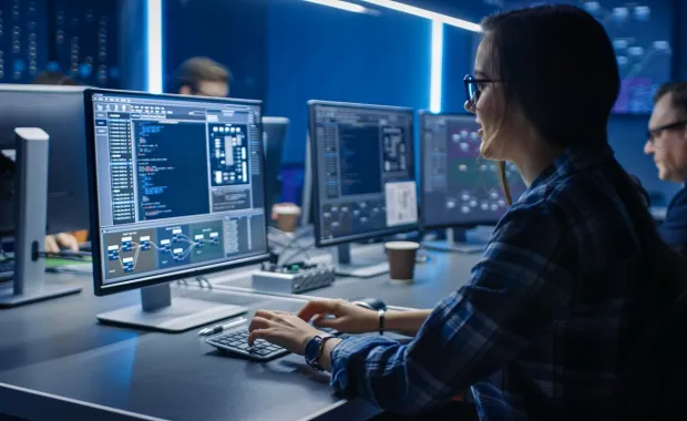 Professionals working with AI assistance in front of computer screens
