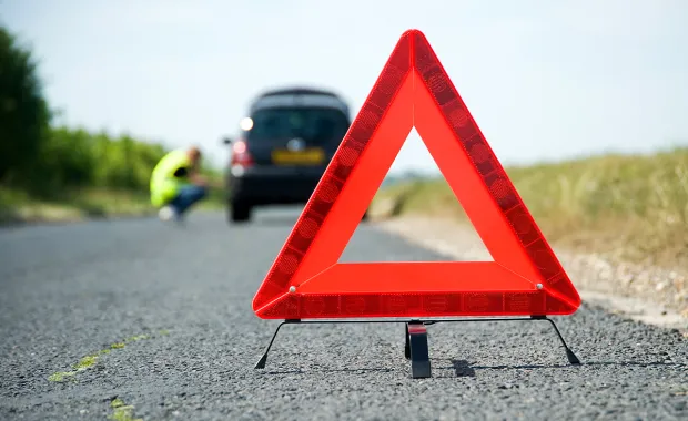 Red warning triangle on the road for car breakdown