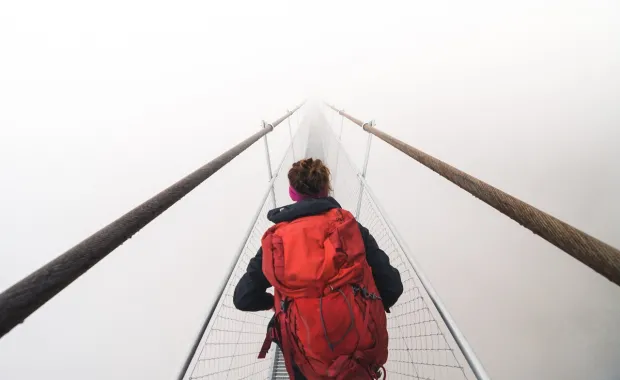 woman with a red backpack charting a path