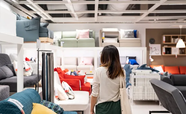 Kvinne ser på utstilte sofaer i en møbelbutikk