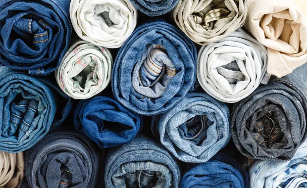 pile de différents jeans roulés