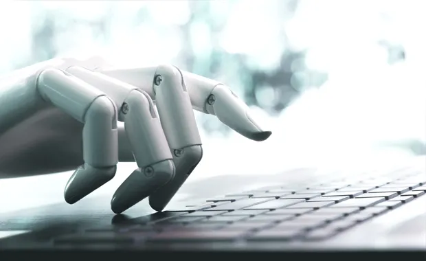 Vit robothand som skriver på ett tangentbord