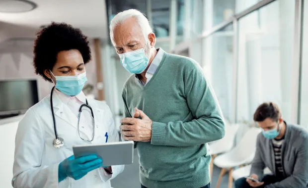 Un médecin et un patient en train de regarder une tablette tactile