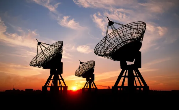 3 satellites with a sunset in the background 