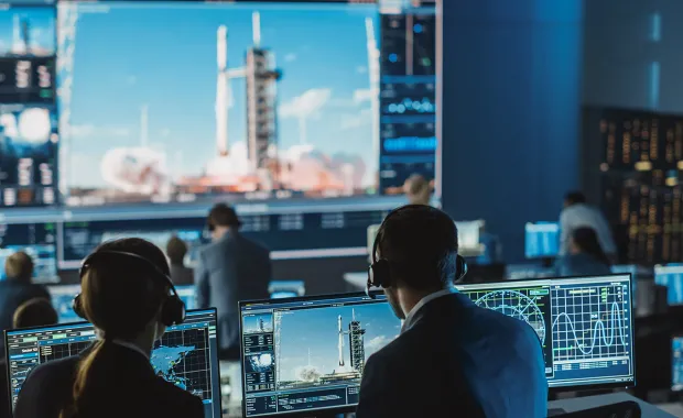 une équipe de contrôle de mission observe un lancement de fusée, représentant les solutions spatiales de CGI