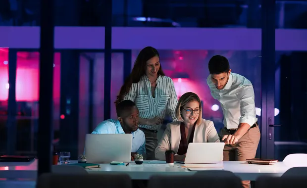 Tiimi katsomassa asiaa yhdessä tietokoneelta