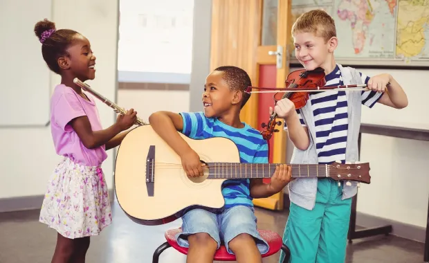 Three children playing musical instrument