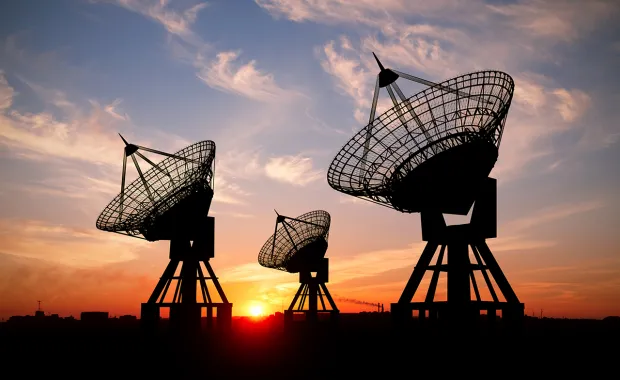 3 satellites dishes in silhouette