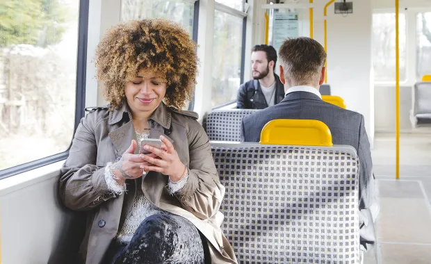 Train passenger uses mobile device