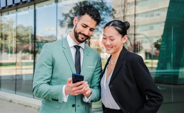 deux personnes consultent une actualité sur un téléphone