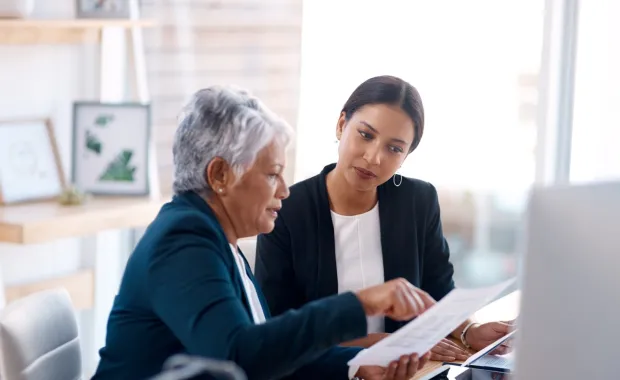 Two professionals seated reviewing a document