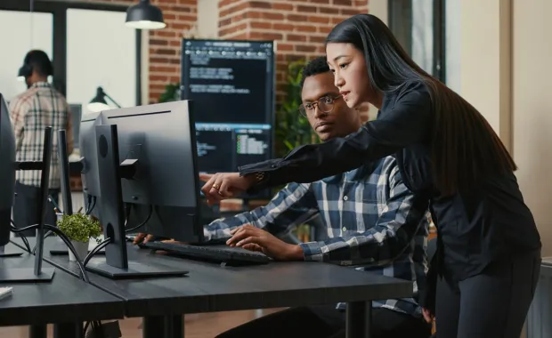 Two programmers working on a external monitor