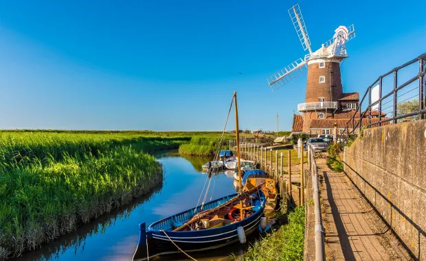 windmill along rural riverbank in Norfolk