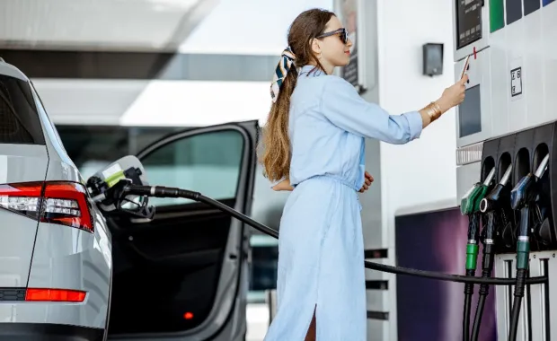 Woman filling up car at petrol station