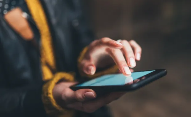 Woman taps mobile phone screen
