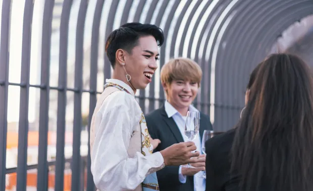 Drei Personen stoßen mit Sektgläsern an