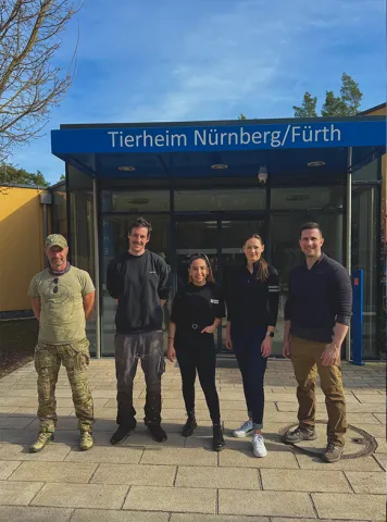 Bersu Erdemir steht mit anderen Tierpflegern vor dem Tierheim Nürnberg/Fürth