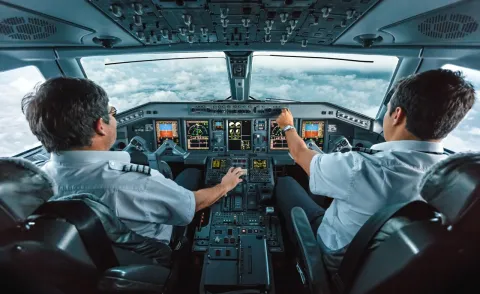 View of inside of plane cockpit from behind pilots View of inside of plane cockpit from behind pilots