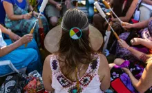 native american woman with back to camera leads drum circle