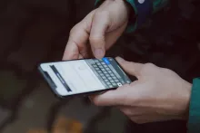 Närbild på två händer som håller en smartphone