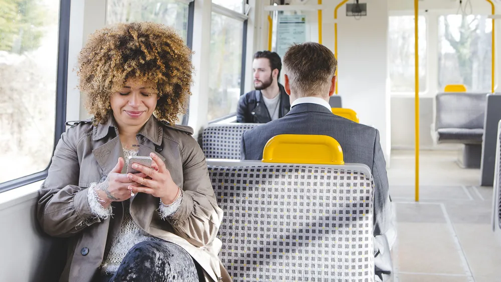 Train passenger uses mobile device