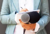 Analyst holding microphones and notepad