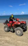 Yohance sur un véhicule tout-terrain à la plage