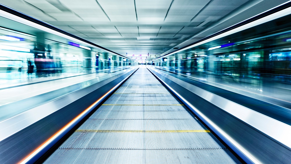 Symmetric moving blue escalator inside a contemporary airport