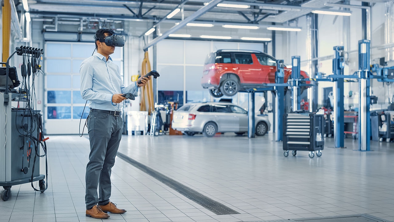 technician using virtual reality headset in car repair workshop