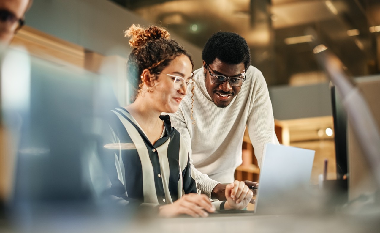 Zwei Mitglieder eines IIoT-Projektteams arbeiten gemeinsam an einem Laptop im Büro. Zwei Mitglieder eines IIoT-Projektteams arbeiten gemeinsam an einem Laptop im Büro.