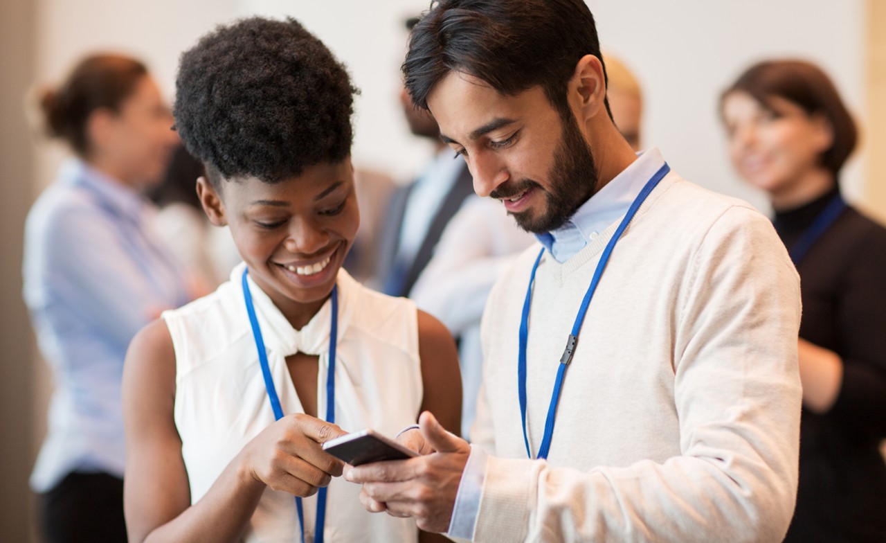 Two people looking at a smartphone at an event