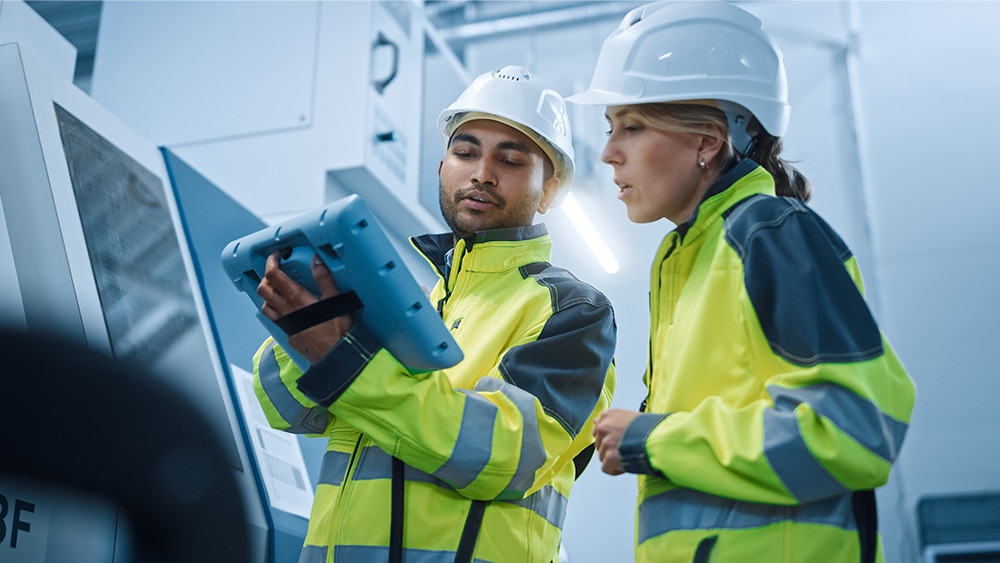 two utilities workers looking at a tablet