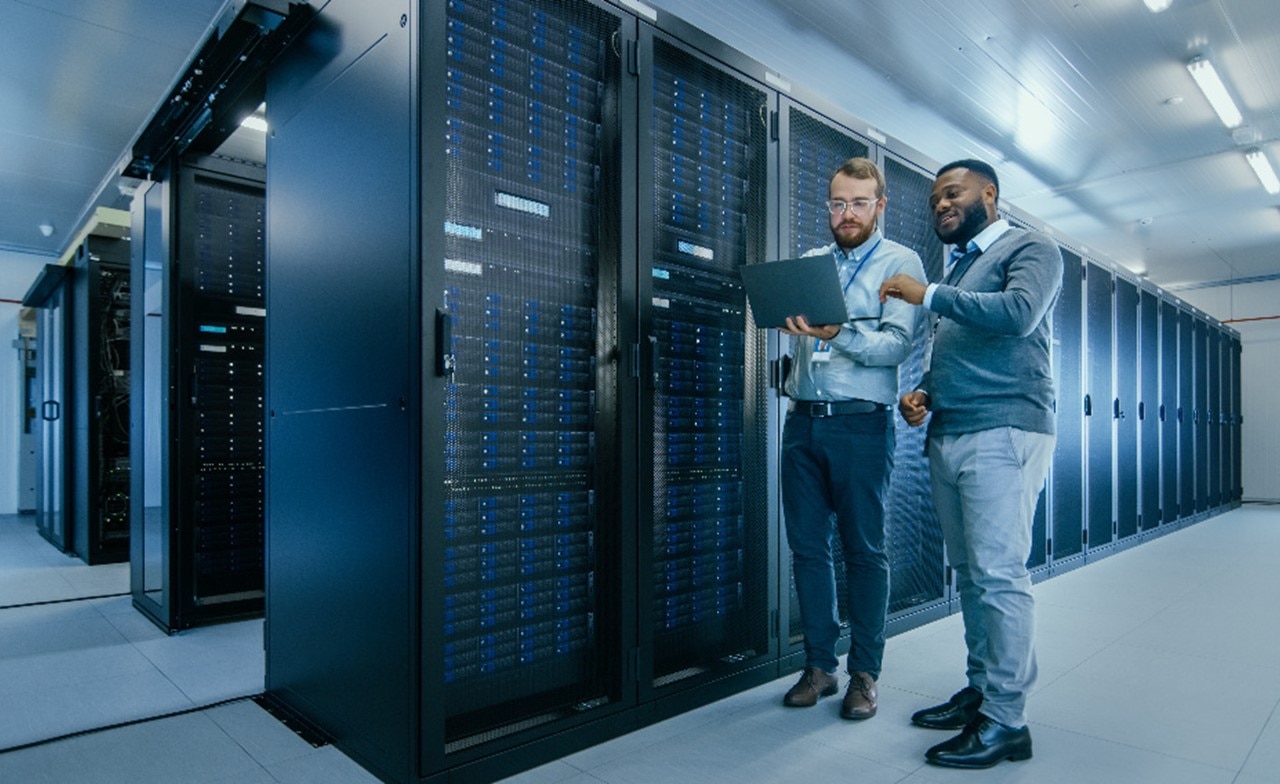 Two SovereignOps consultants look at laptop in server room