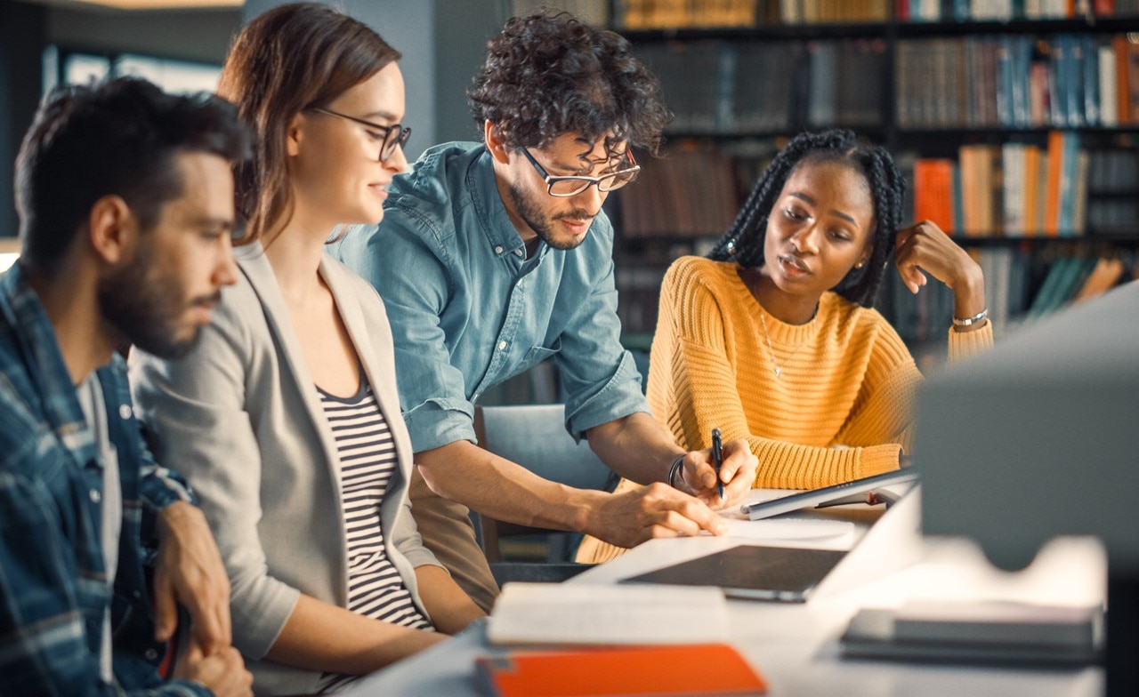 University students looking at laptop together