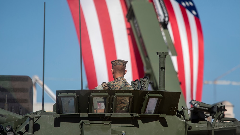 U.S. Marine in vehicle with flag in background us marine in vehicle with flag in background