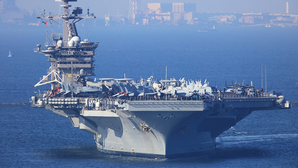 us navy ship with city in background