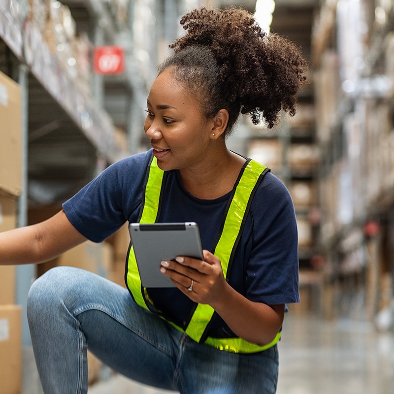 Varastotyöntekijä käyttää toiminnanohjausjärjestelmää tabletilla