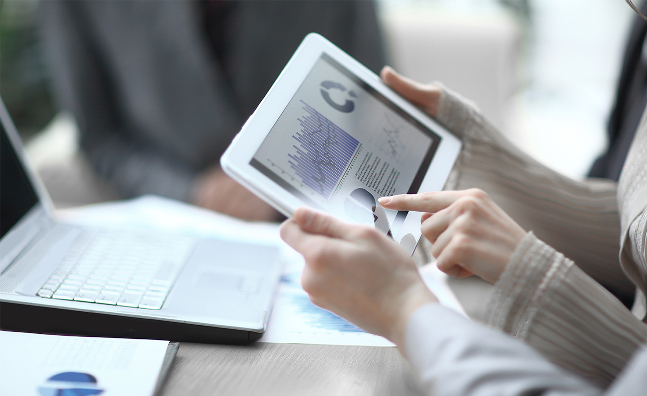 Il team di gestione patrimoniale utilizza un tablet per verificare i dati finanziari