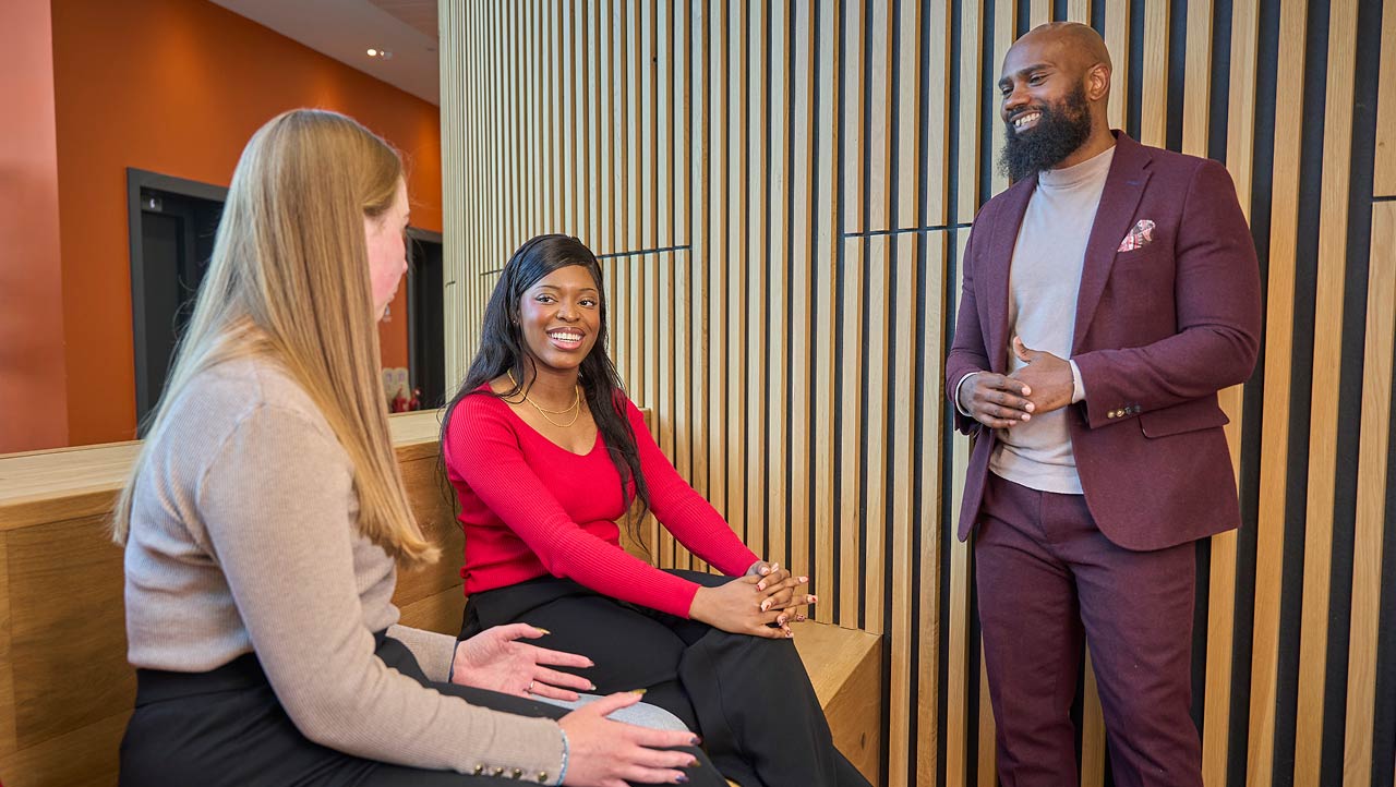 Medium side shot of young woman sat at desk on her laptop