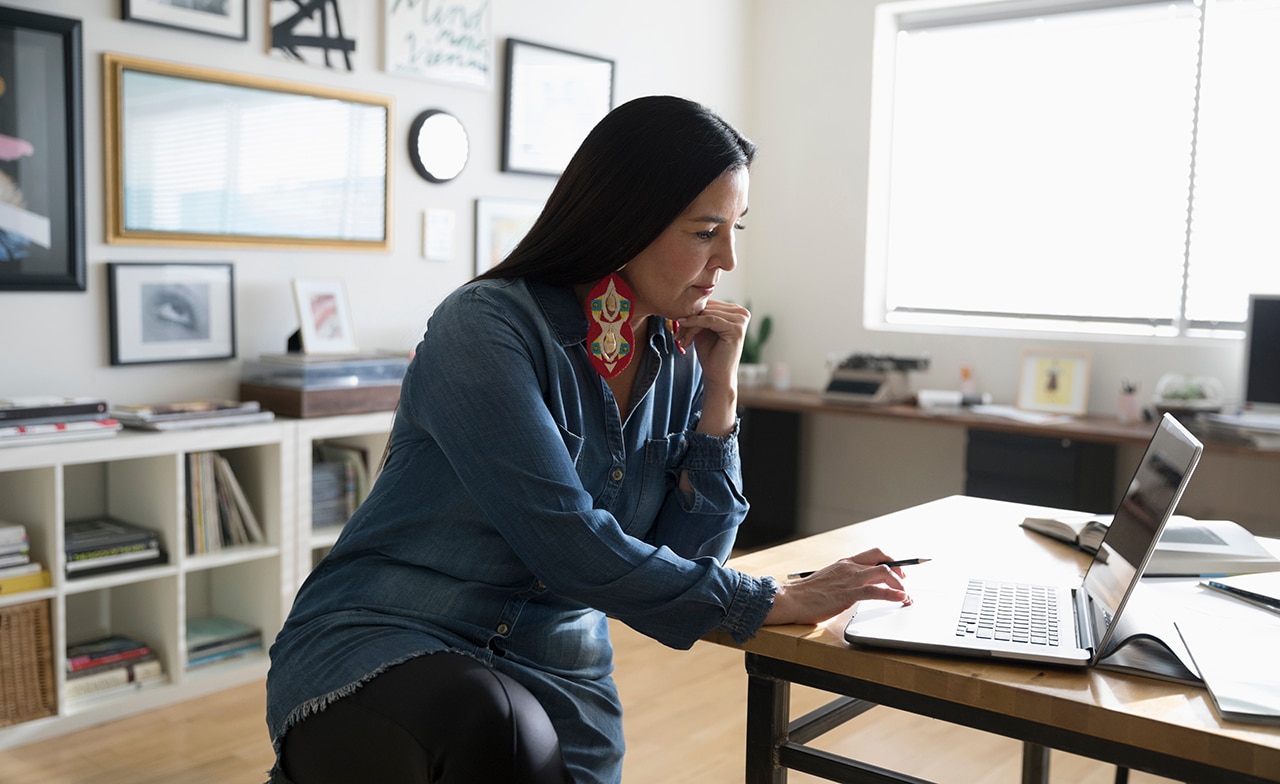 native woman in house with laptop