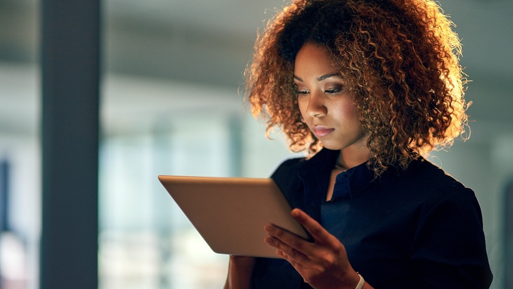 A young businesswoman using a digital tablet on a late night