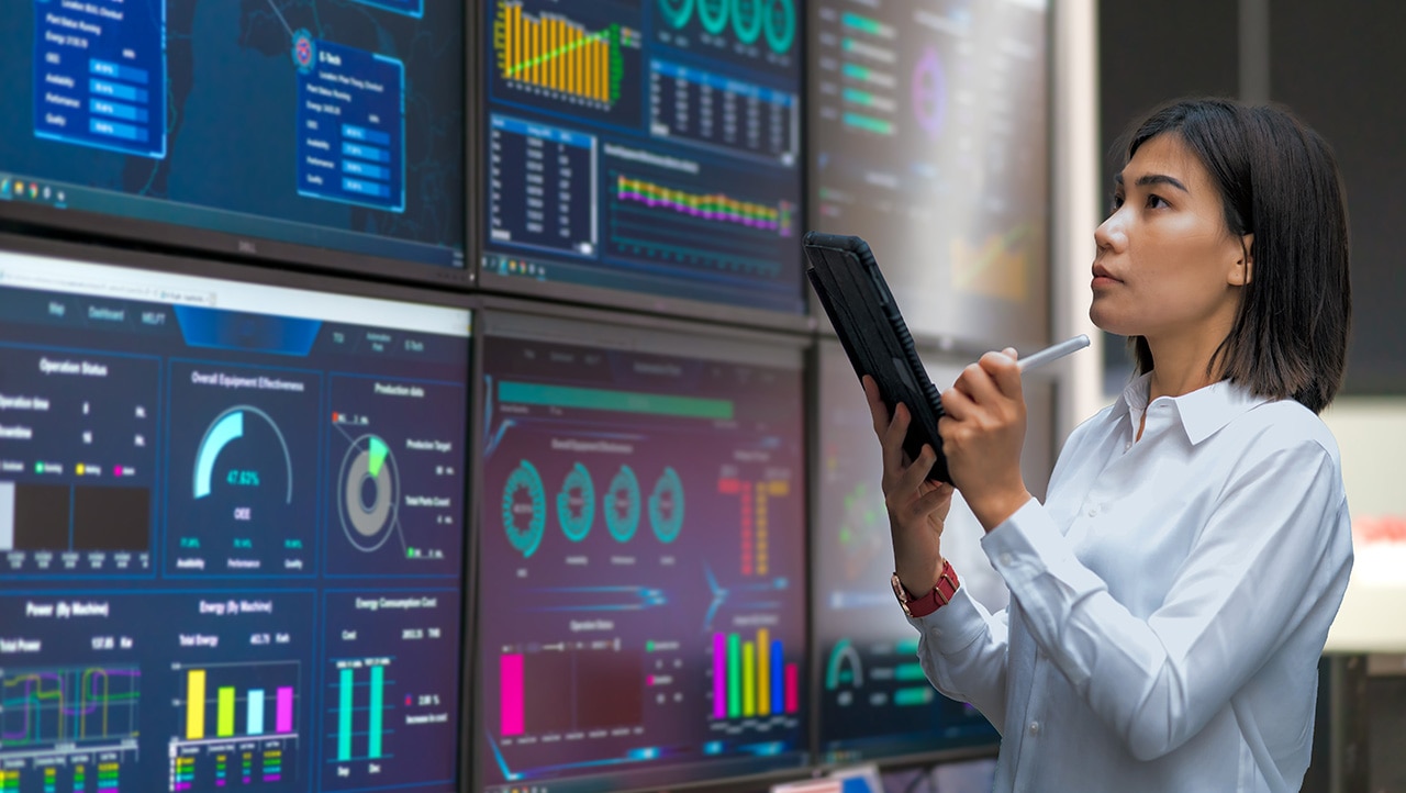 Woman looking at the stats on wide screen Woman looking at the stats on wide screen