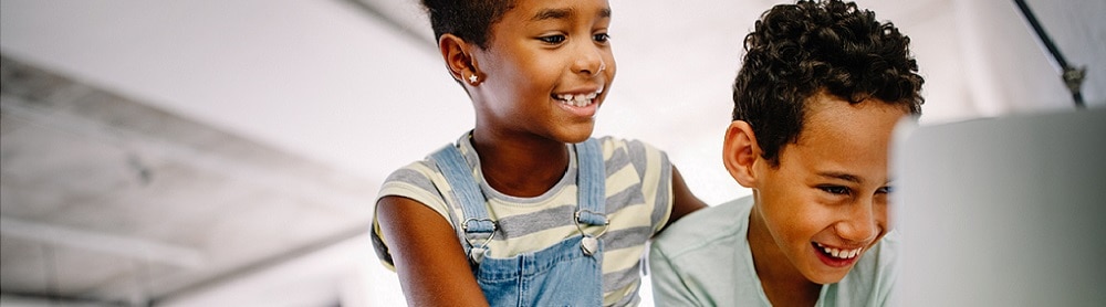 Kommunikation Två barn läser och skrattar medan de tittar på skärmen